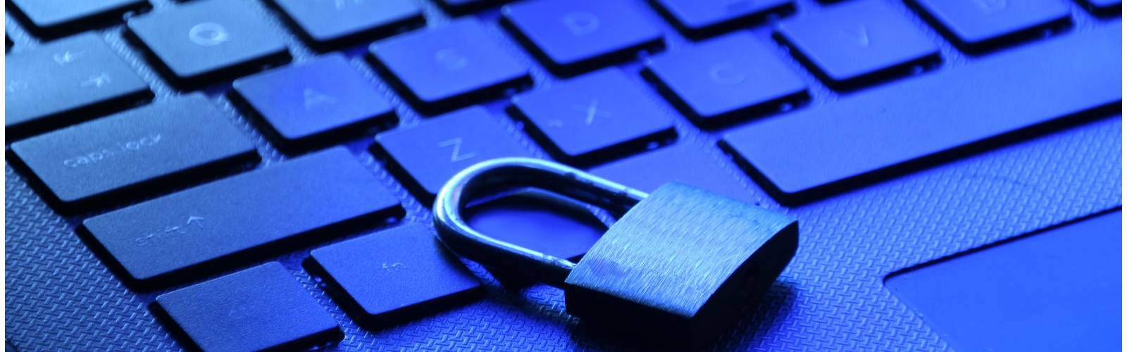 Padlock atop a laptop keyboard illuminated in blue