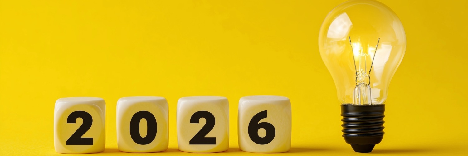 A lightbulb on the right hand side of four cubes displaying the year 2026, all on a yellow background