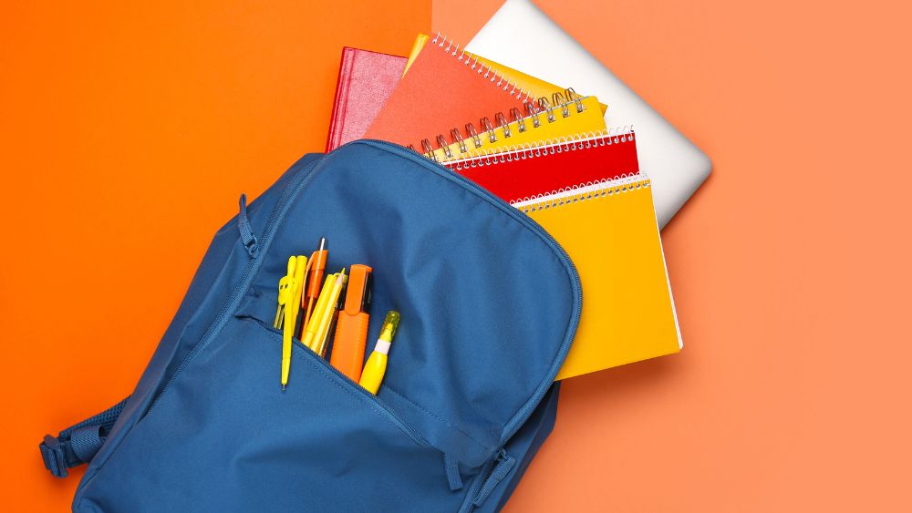 Blue school backpack containing books and a laptop