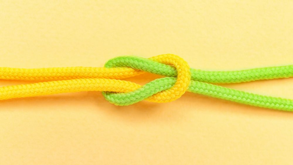 Yellow and green ropes tied securely together, representing a strong partnership